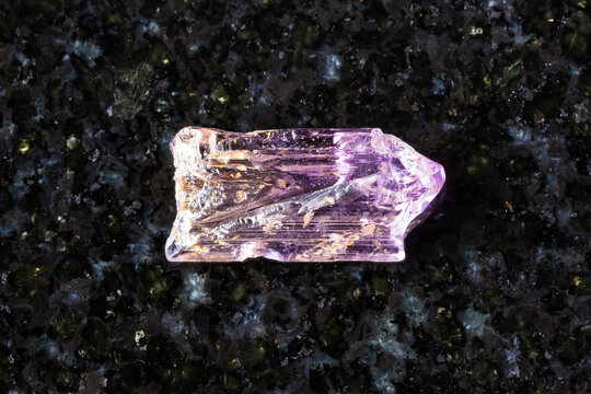 sample of rough purple scapolite crystal on black