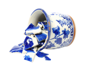 A smashed ceramic vase, isolated on a white background, perfect for use in themes of damage, broken objects, or art.