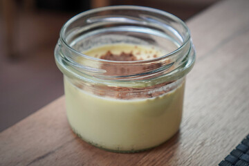 Single glass jar with creamy dessert and crumb topping ready for tasting