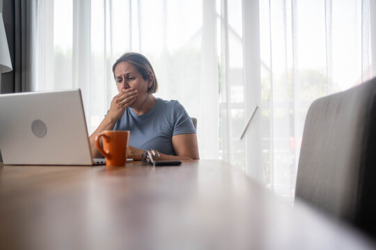 Sick woman coughing while working from home on laptop, allergy or flu symptoms in home office environment - Powered by Adobe