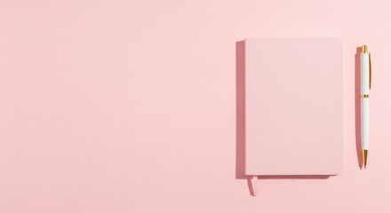 Pink notebook and pen flat lay on a matching pink background