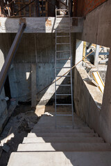 Scaffolding at a construction site. Stairs architecture unfinished at house. Building with a metal...
