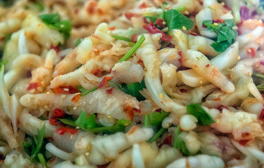 Close-up of a traditional Asian dish of chicken feet with hot sauce, herbs and spices.  