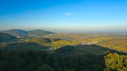 Palatinate Forest, Germany: An aerial view from the edge of the Palatinate Forest, showcasing the transition from forested hills to the flat Rhine Valley, with a village and agricultural fields in the