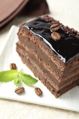 Piece of chocolate cake served with mint on white table, closeup