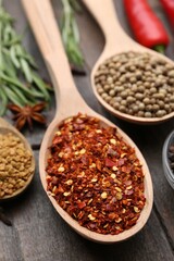Different aromatic spices on wooden table, closeup