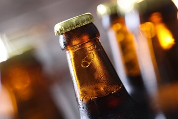 Bottle of tasty beer on blurred grey background, macro view
