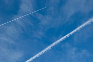 dettaglio del cielo azzurro, di giorno, con varie nuvole molto leggere e trasparenti ed alcune scie...