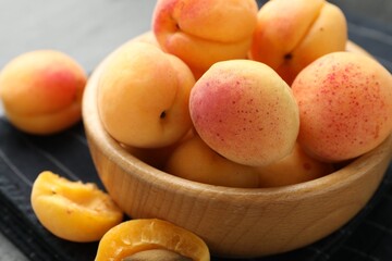 Fresh ripe apricots in bowl on table, closeup