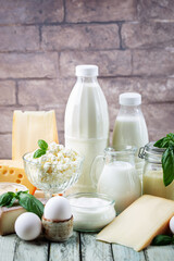 Fresh dairy products, milk, cottage cheese, eggs, yogurt, sour cream and butter on wooden table
