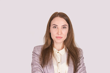 Confident caucasian female young adult in professional attire with long brown hair and light...