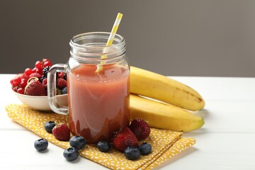 Superfood. Healthy drink in mason jar and ingredients on white wooden table against grey...