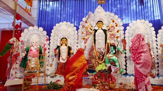 devotee offering prayers to goddess durga idol during dussehra in daylight