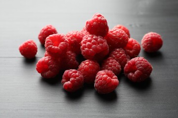 Tasty fresh ripe raspberries on black table, closeup