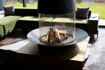 transparent modern glass fireplace with firewood in the interior