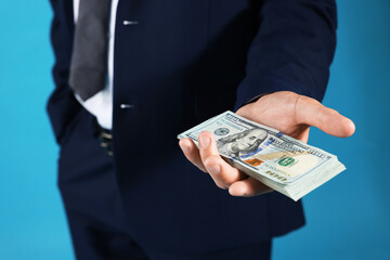 Man with dollar bills on blue background, closeup