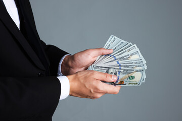 Man with dollar bills on grey background, closeup