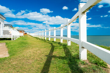 Newly erected plastic cliff edge fence seen adjacent to summer holiday static caravans with a view...