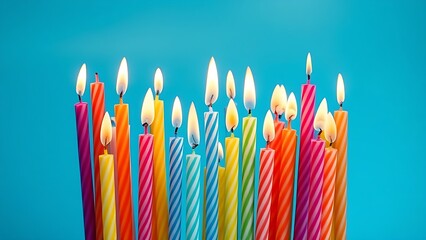 Colorful birthday candles of varying heights glowing softly, arranged on a gradient blue background.