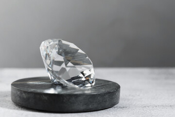 Aura. Beautiful diamond on white textured table, closeup. Space for text