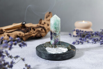 Aura. Different crystals, lavender, burning candle and Palo Santo on white textured table, closeup
