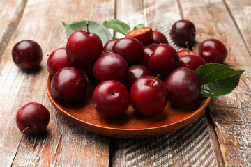 Ripe cherry plums on color wooden table, closeup