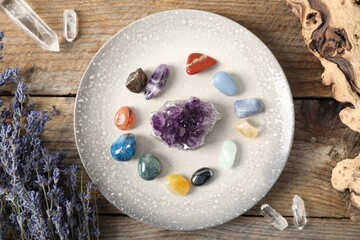 Aura. Different natural mineral stones, lavender and snag on wooden table, flat lay