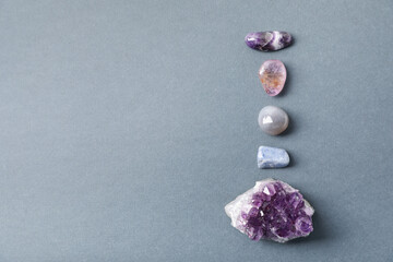Aura. Different natural mineral stones on grey background, above view. Space for text