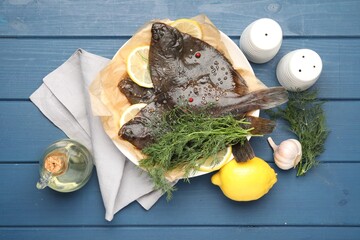 Fresh raw flounder fish and spices on blue wooden table, flat lay. Seafood