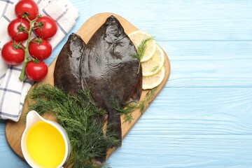 Seafood. Fresh raw flounder fish and ingredients on light blue wooden table, flat lay. Space for...