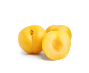 Whole and cut yellow cherry plums isolated on white