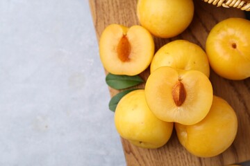 Ripe yellow cherry plums on grey table, closeup. Space for text