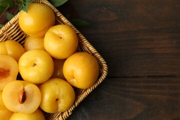Ripe yellow cherry plums on wooden table, flat lay. Space for text