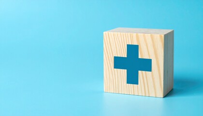 Fototapeta premium A wooden block with a blue cross symbol, signifying health and wellness. It sits against a light blue backdrop