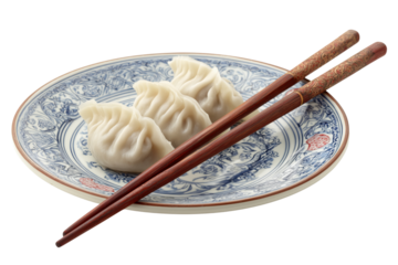 Three white dumplings on a blue and white patterned plate with chopsticks isolated on a transparent background