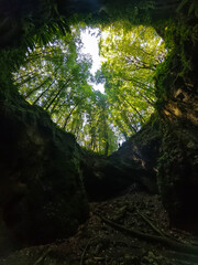 Upward view from inside Dante's Hell Cave (Udvar-kő) in the Bükk Mountains, Hungary, framed by...