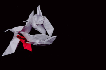 Paper boats Leadership and standing out from the crowd in white and red with a black background.