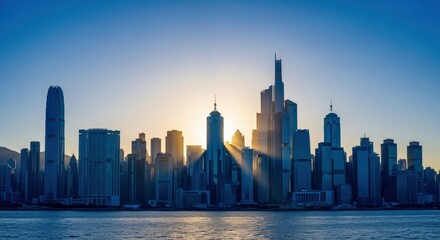 Obraz premium Hong Kong Skyline at Dawn with Sunburst, showcasing Modern Architecture and Urban Landscape against Blue Sky