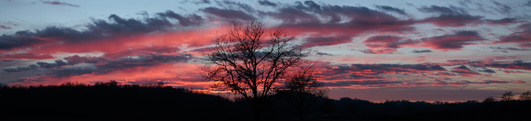 vista panoramica su di un ambiente naturale di campagna, cielo parzialmente nuvoloso, al tramonto,...