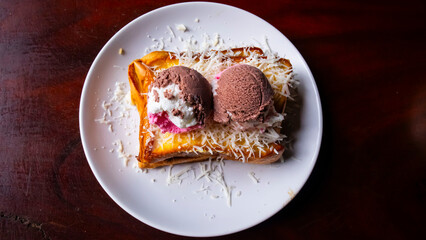 toast, ice cream and cheese flakes on a white plate on the table