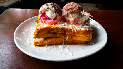 toast, ice cream and cheese flakes on a white plate on the table