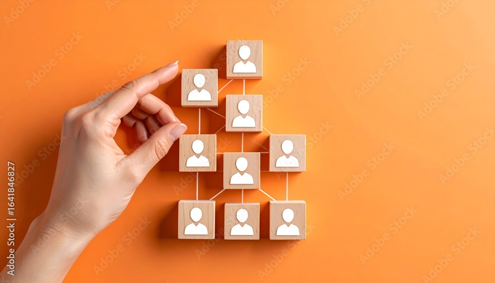 Poster hand arranging a conceptual human organizational structure on orange background. a symbol of interco