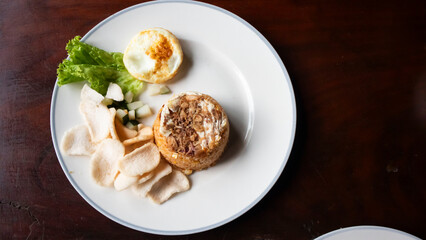 a dish of fried rice, fried eggs and crackers, a typical Indonesian dish