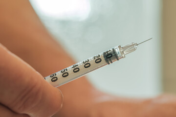 Patient holds syringe and prepares to inject glp-1 medication