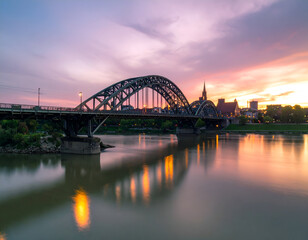 Obraz premium Steel Bridge at Sunset Over City River Reflection