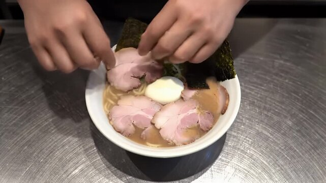 Close Up of Hands Preparing Traditional Japanese Ramen Meal