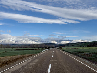 Scenic road towards a Palencia village with mountain backdrop