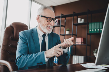 Mature businessman in formal suit working at office desk focusing on computer screen in a...