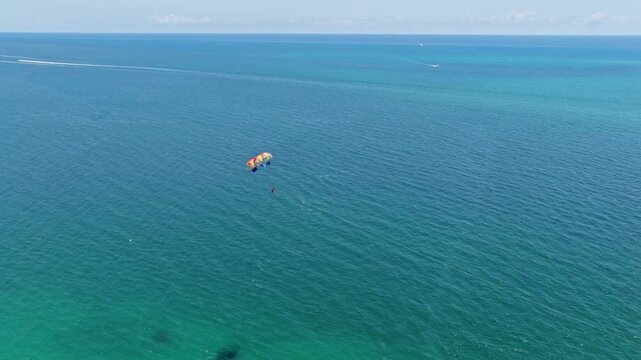 Parasailing sport activity. Parachute in the sky. Extreme rest and parasailing. Summer vacation. Sea sport. Parachute parasail. Water sport on summer vacation. Parasailing recreation with parachute