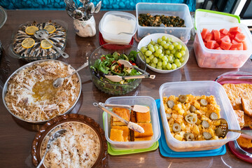 A vibrant spread of homemade dishes on a wooden table, featuring salads, fruits, and main courses, ready for a family gathering or celebration.